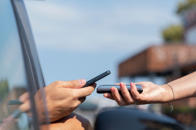 Kunde zahlt mit seinem Telefon bei einer Abholung am Straßenrand