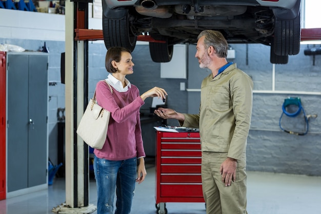 Kunden geben ihre Autoschlüssel zu Mechaniker