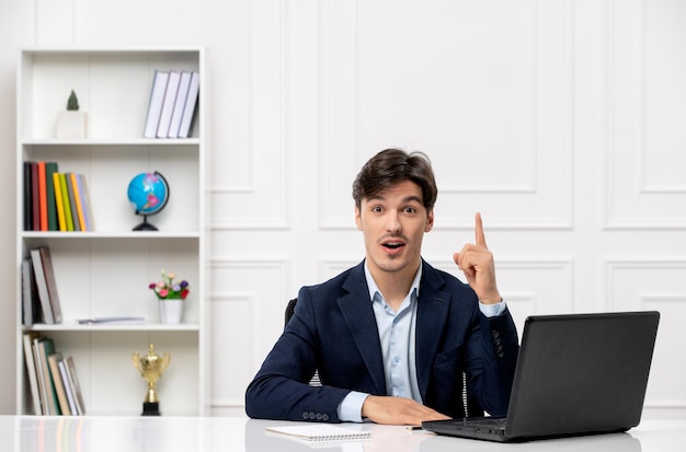 Kundenservice gutaussehender Kerl im Büroanzug mit dem Computer, der eine Idee hat