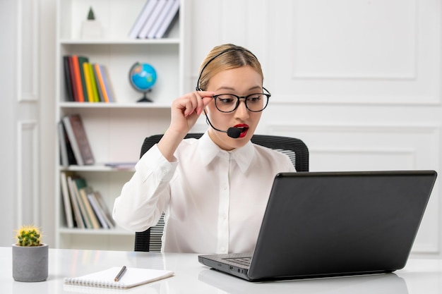 Kundenservice süßes schönes Mädchen in weißem Hemd mit Computer und Headset beim Videoanruf