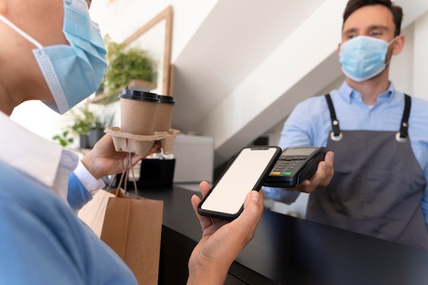 Kundin bezahlt Essen zum Mitnehmen mit Smartphone