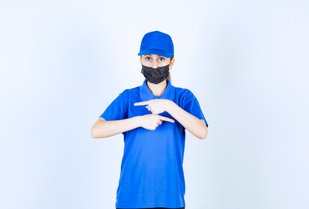 Kurierin in Maske und blauer Uniform, die beide Seiten zeigt.