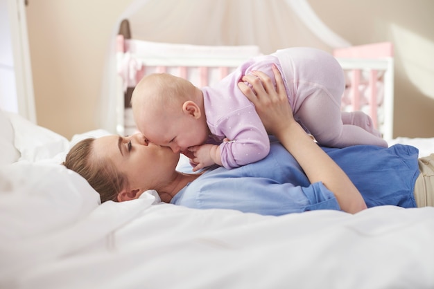 Kuschelt mit Mama im Bett