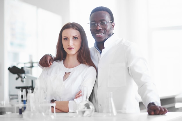 Laboratorien führen Experimente in einem chemischen Labor in transparenten Kolben durch. Ausgabeformeln.