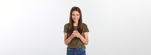 Lachende Frau, die auf einem weißen Hintergrund spricht und am Telefon SMS schreibt