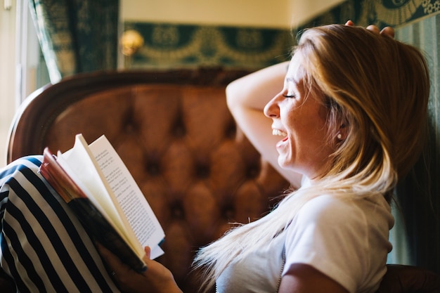 Lachende Frau, die Buch genießt