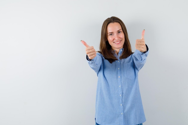 Lachende Frau mit einem guten Handzeichen auf weißem Hintergrund