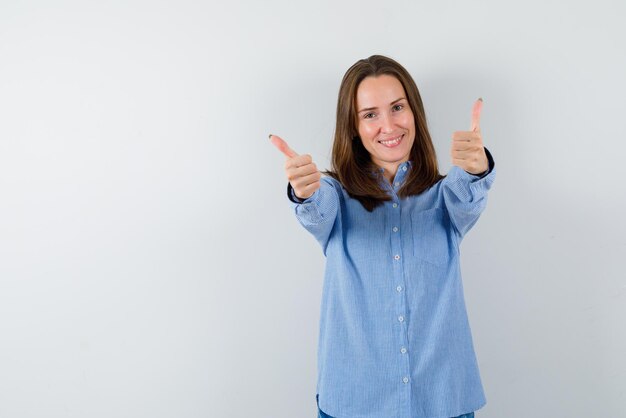 Lachende Frau mit einem guten Handzeichen auf weißem Hintergrund