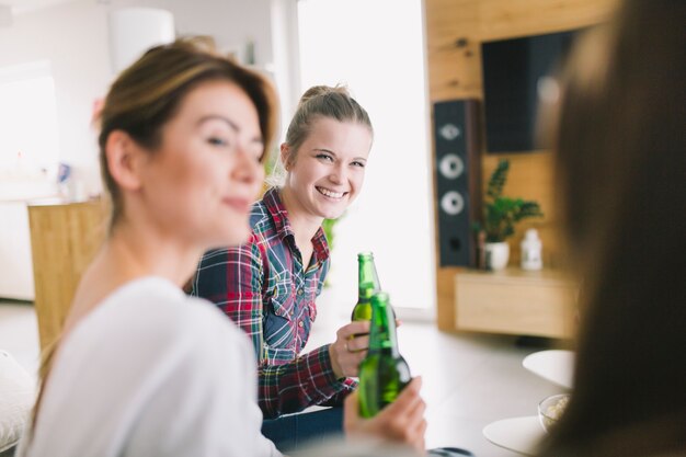 Lachende Frauen, die zusammen Bier trinken