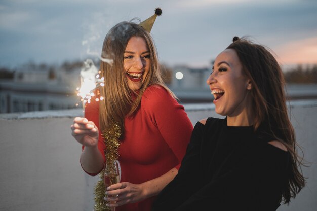 Kostenloses Foto lachende frauen halten die wunderkerzen