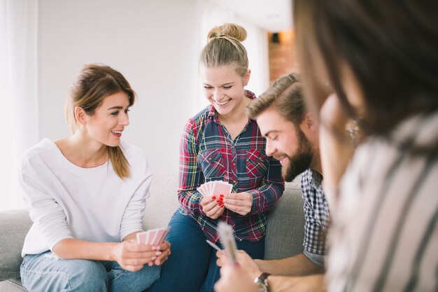 Lachende Freunde, die Kartenspiel genießen