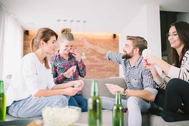 Lachende Freunde, die Spaß mit Spielkarten haben