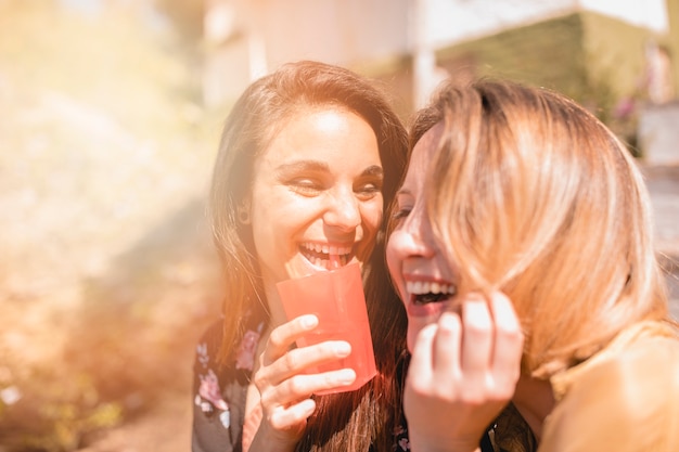 Lachende Freunde mit Getränk