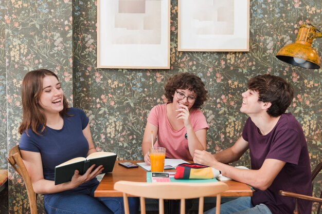 Lachende Jugendliche, die im Café studieren