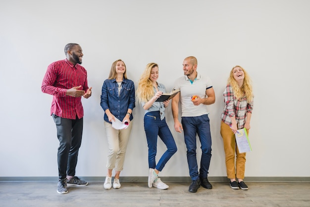 Lachende Studenten posieren mit Notebooks