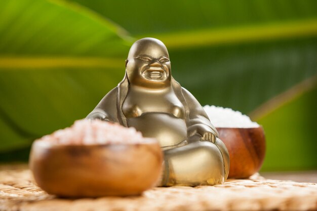 Lachender Buddha-Figur und Meersalz in Holzschale