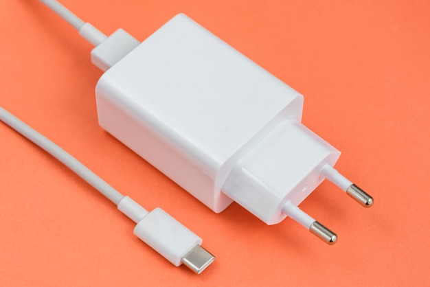 Ladegerät und USB-Kabel Typ C über rotem Hintergrund