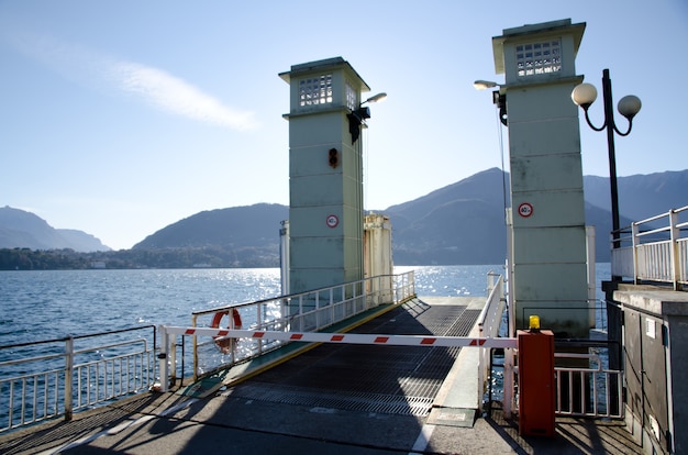 Laderampe am Ende eines Piers am Wasser mit den Bergen