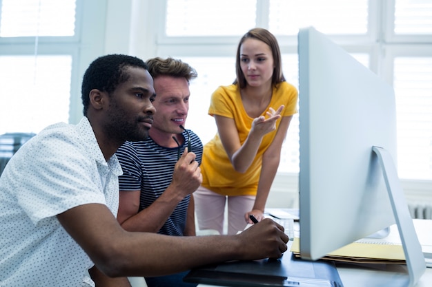 Lächelnde Arbeitskraft, während andere ernst aussehen