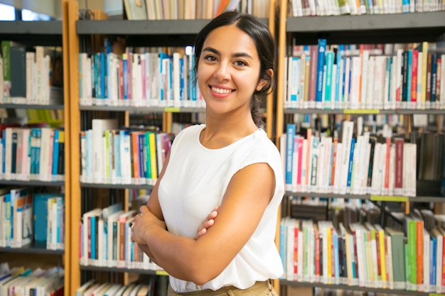 Lächelnde asiatische Frau, die an der öffentlichen Bibliothek aufwirft