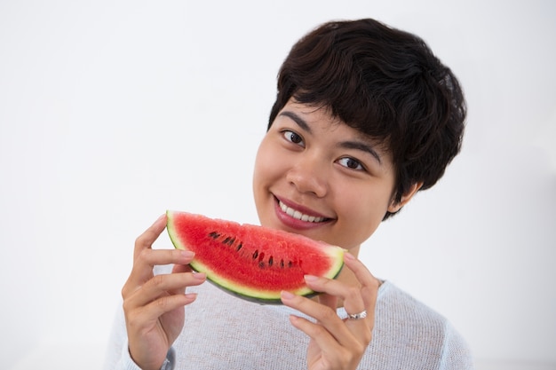 Lächelnde asiatische Frau hält Scheibe Wassermelone