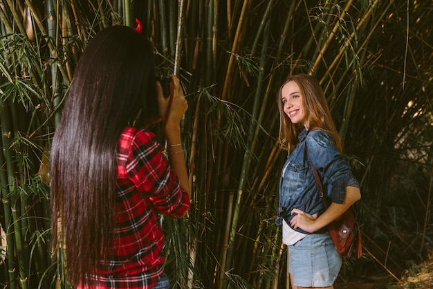 Lächelnde aufwerfende Frau während ihr Freund Foto mit Kamera macht