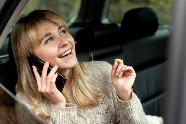 Lächelnde blonde Frau, die am Telefon spricht