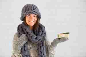 Kostenloses Foto lächelnde dame in handschuhen, mütze und schal mit präsentkarton