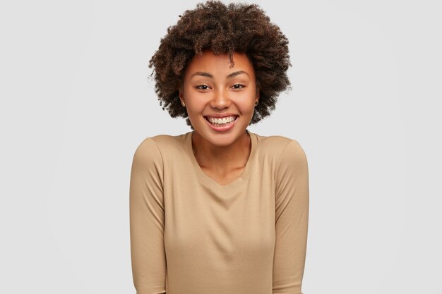 Lächelnde dunkelhäutige Frau hat Afro-Frisur