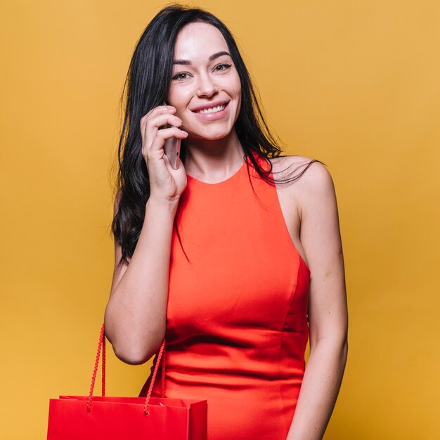 Lächelnde Einkaufsfrau, die am Telefon spricht