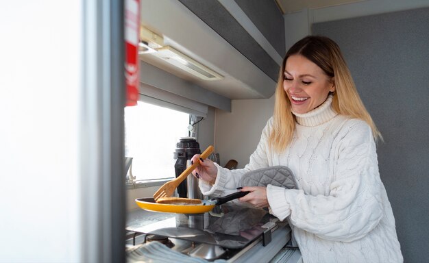 Lächelnde Frau des mittleren Schusses, die kocht