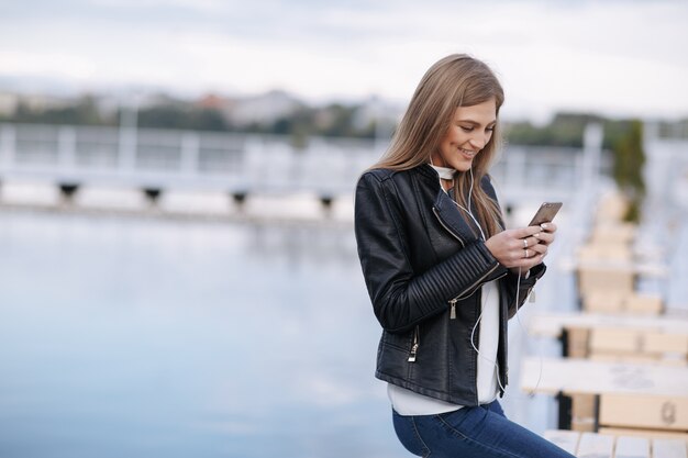 Lächelnde Frau, die auf ihrem Smartphone