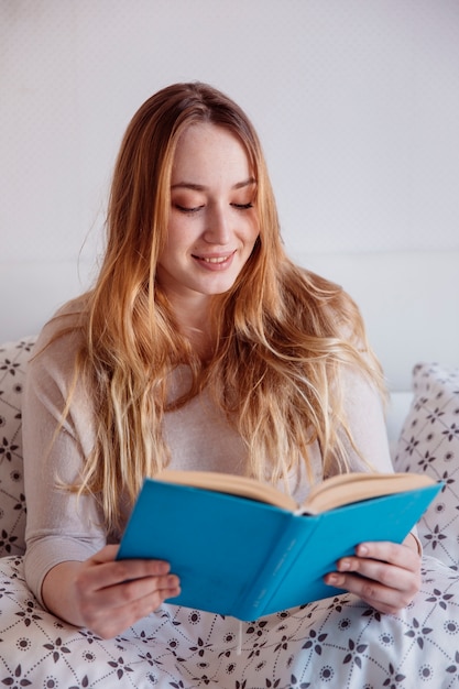 Kostenloses Foto lächelnde frau, die das lesen genießt