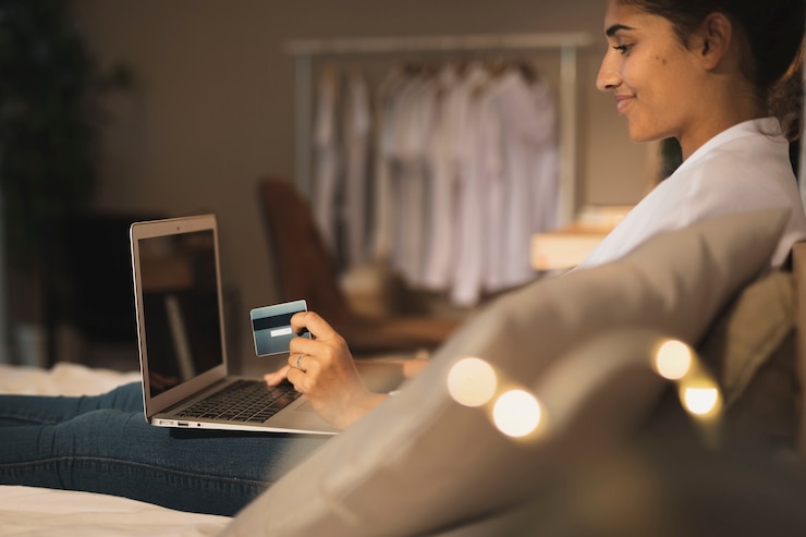 Kostenlose Foto lächelnde frau, die eine karte hält und an laptop arbeitet