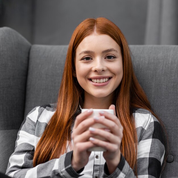 Lächelnde Frau, die einen Becher hält