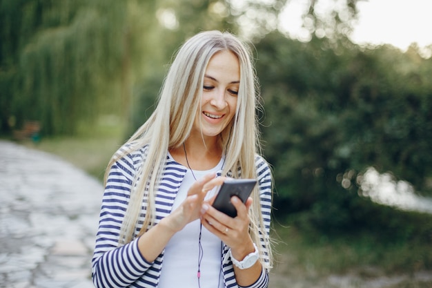 Lächelnde Frau, die Eingabe auf einem Handy