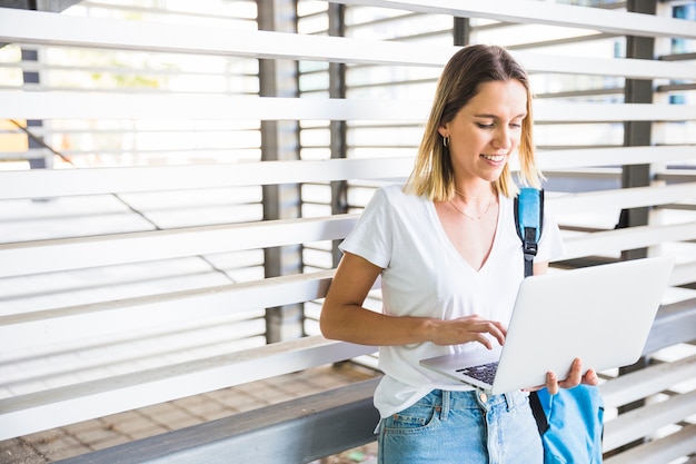 Lächelnde Frau, die Laptop für Studien verwendet