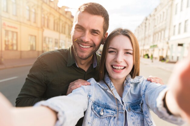 Lächelnde Frau, die selfie mit ihrem Freund auf Straße nimmt