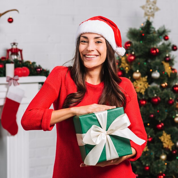 Lächelnde Frau mit grüner Geschenkbox