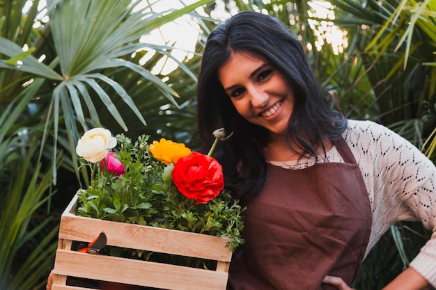 Lächelnde Frau mit Kasten Blumen