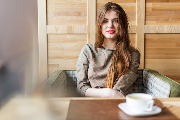 Kostenloses Foto lächelnde frau mit langen haaren in einem café
