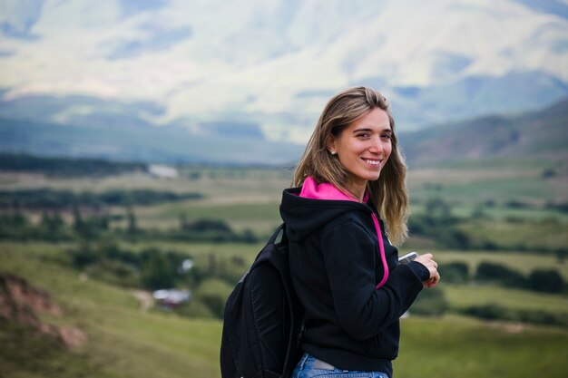 Lächelnde Frau mit unscharfem Naturhintergrund