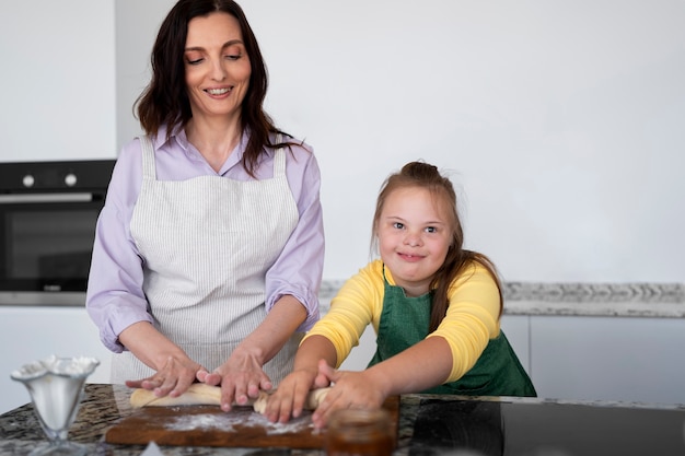 Lächelnde Frau und Mädchen der Vorderansicht kochen