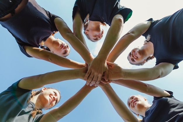 Lächelnde Frauen, die Hände zusammenfügen