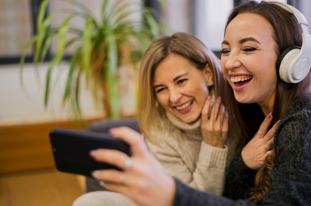 Lächelnde Frauen, die selfie mit Kopfhörern nehmen