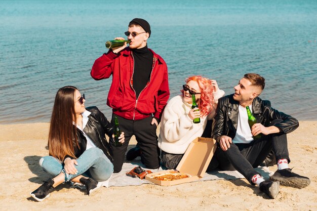 Lächelnde Freunde, die Party am Strand haben