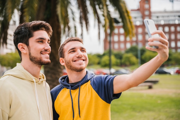 Lächelnde Freunde, die selfie im Park nehmen