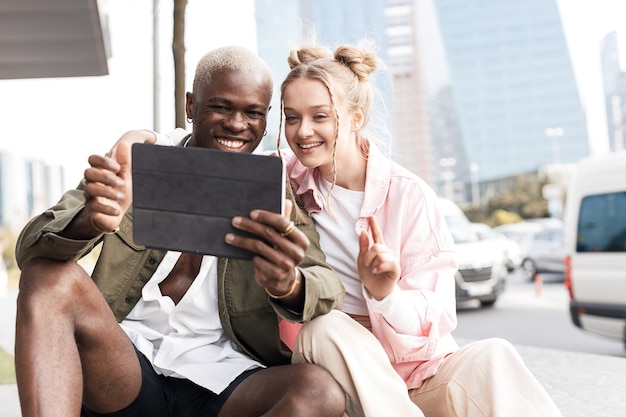 Lächelnde Freunde mit Tablet im Freien