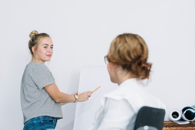 Lächelnde Geschäftsfrau, die neuen Unternehmensplan ihrem Kollegen erklärt