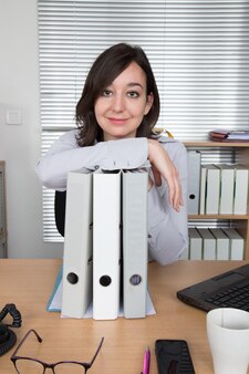 Lächelnde geschäftsfrau mit dokumenten im büro